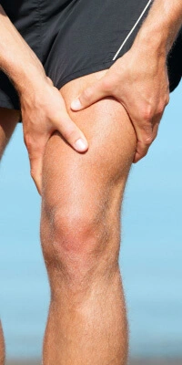 Runner holding his knee in pain